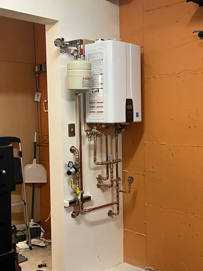Plumbing technician inspecting water heater connections in Berwick